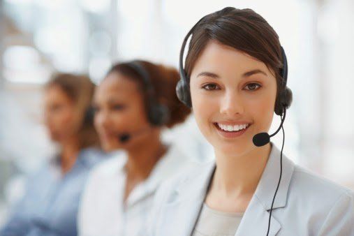 Closeup of a call center employee with headset at workplace