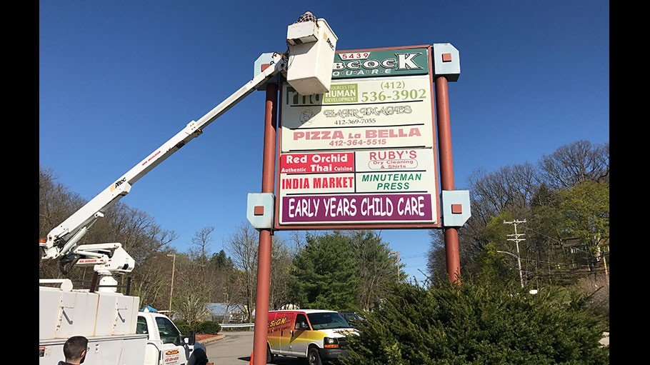 Company installing business sign in a plaza