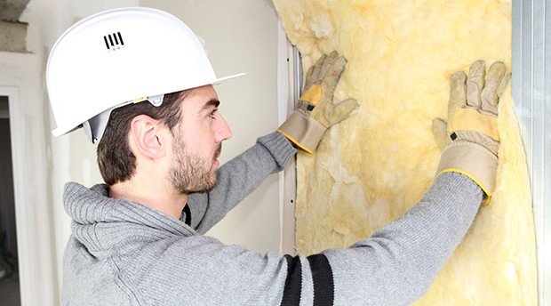 contractor installing insulation in a dry wall to prevent damage to client home